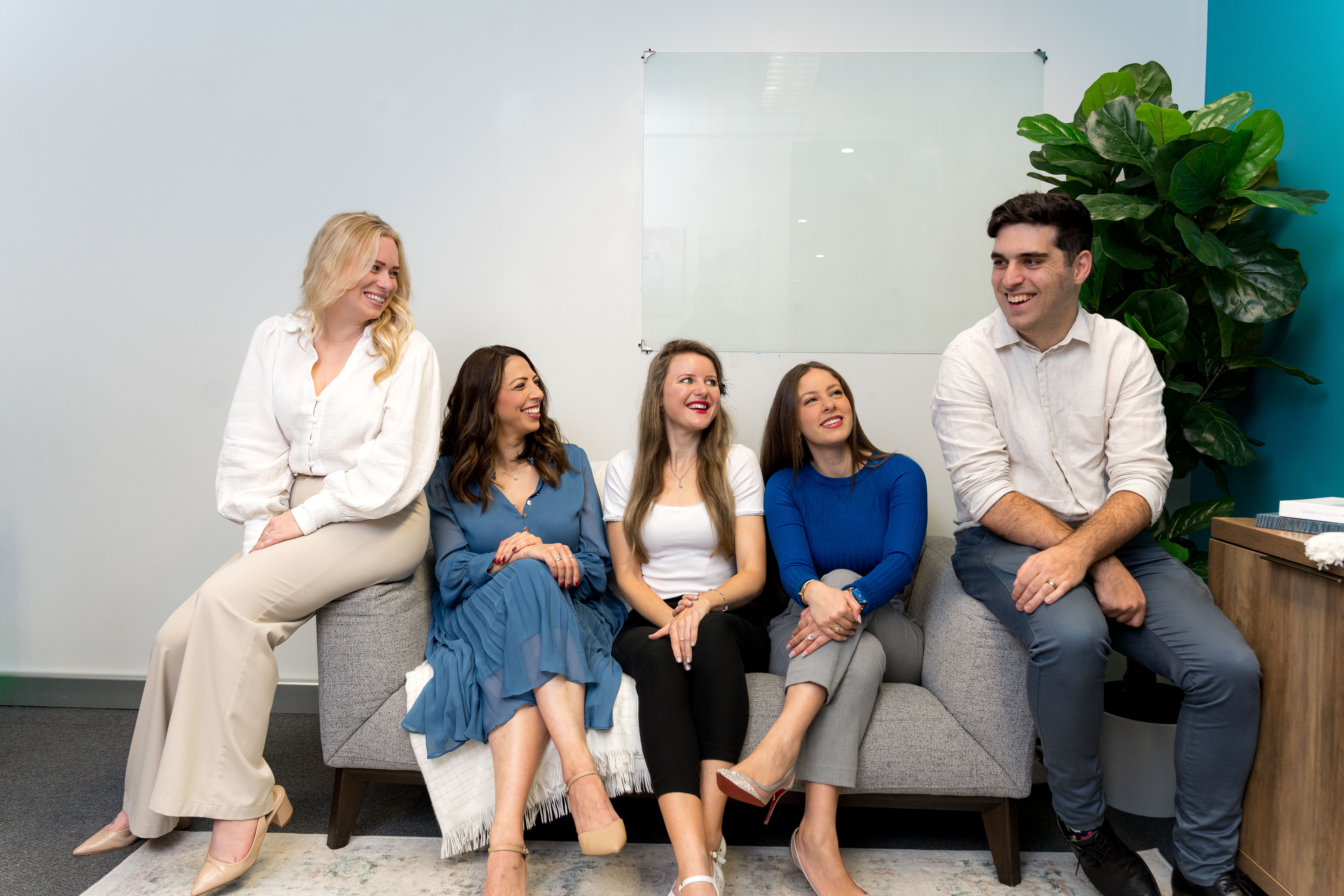 The Social Space team laughing together on the couch in the clinic
