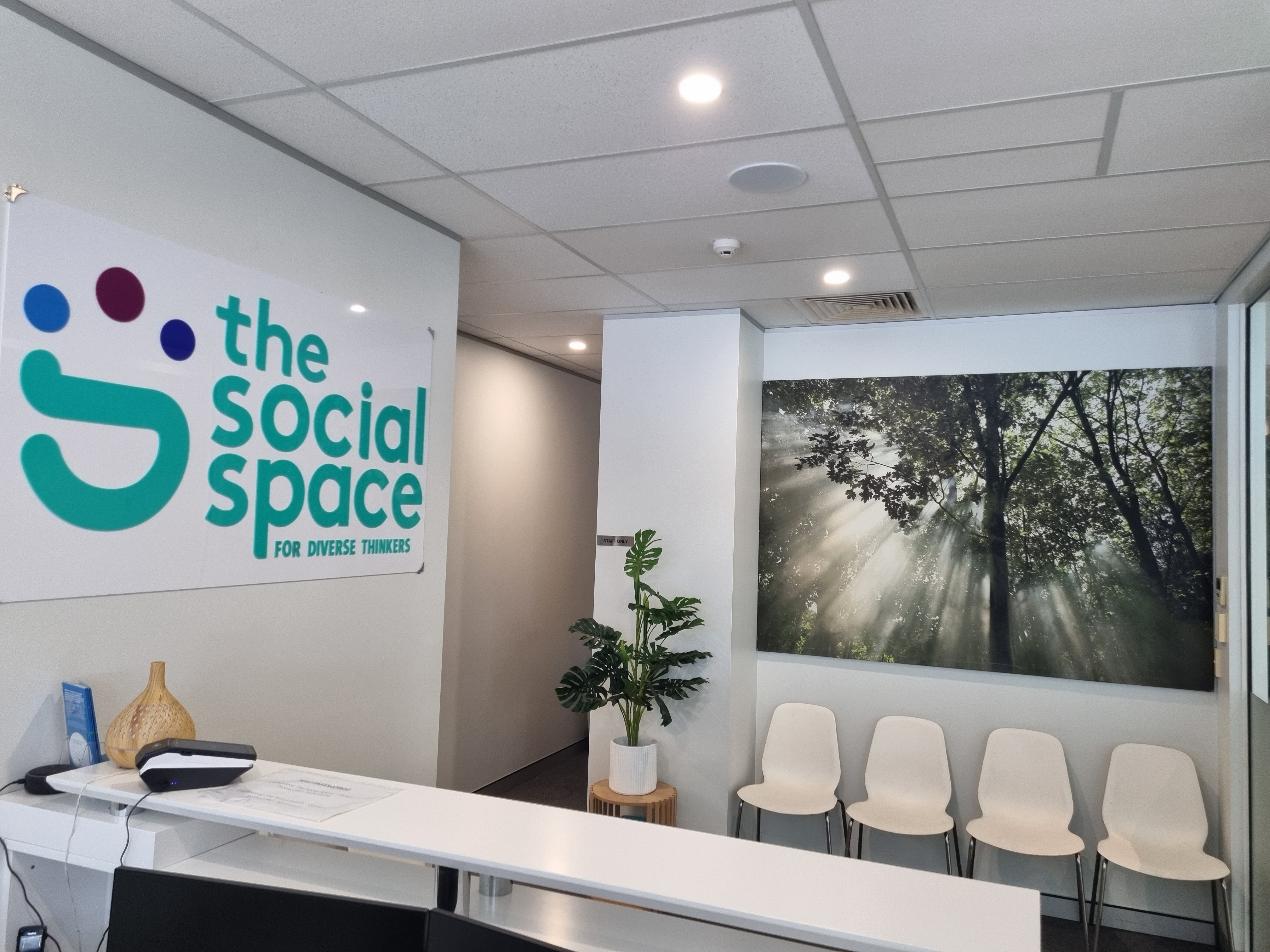 The Social Space reception area, with the clinic's sign and waiting chairs