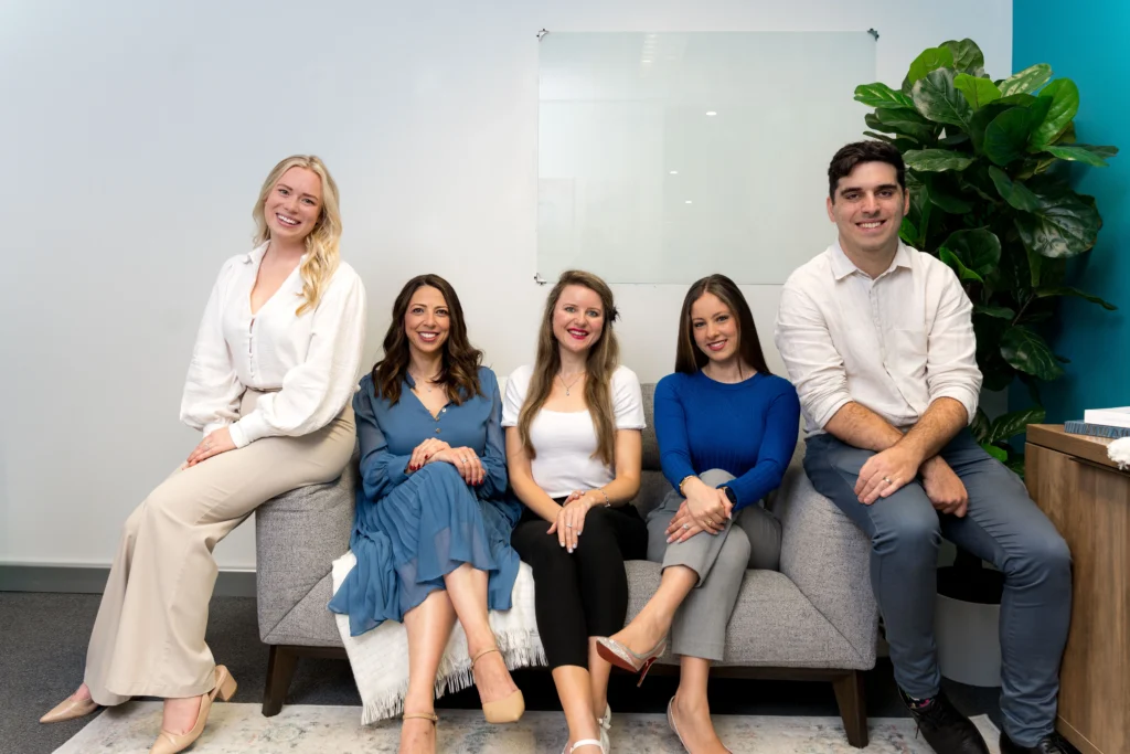 Five members of The Social Space team seated together in the clinic